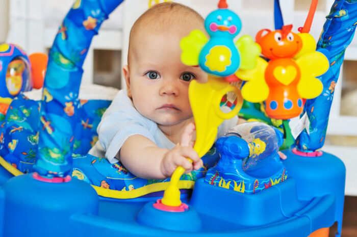 Baby playing with toys in baby bouncer