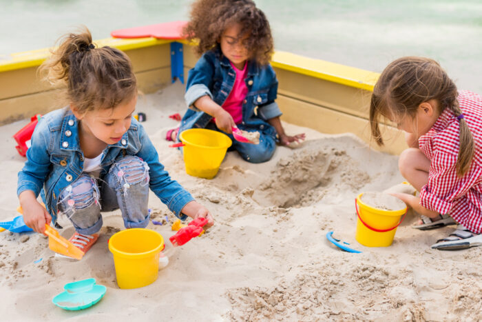 three kids in a sandbox