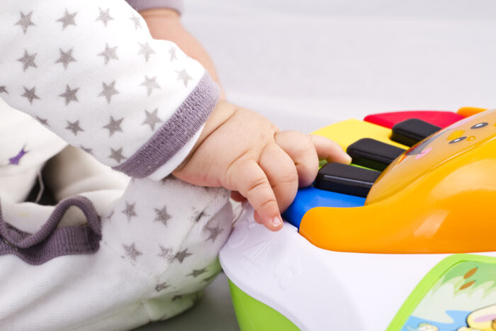 toddler playing a piano toy