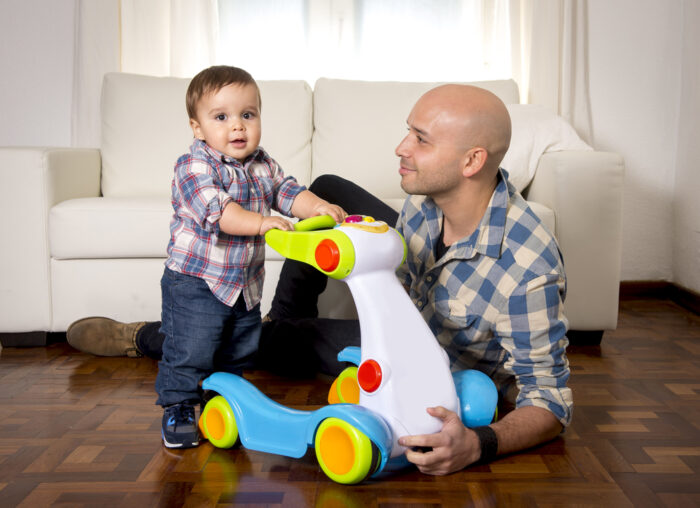 son and father with baby walking toy