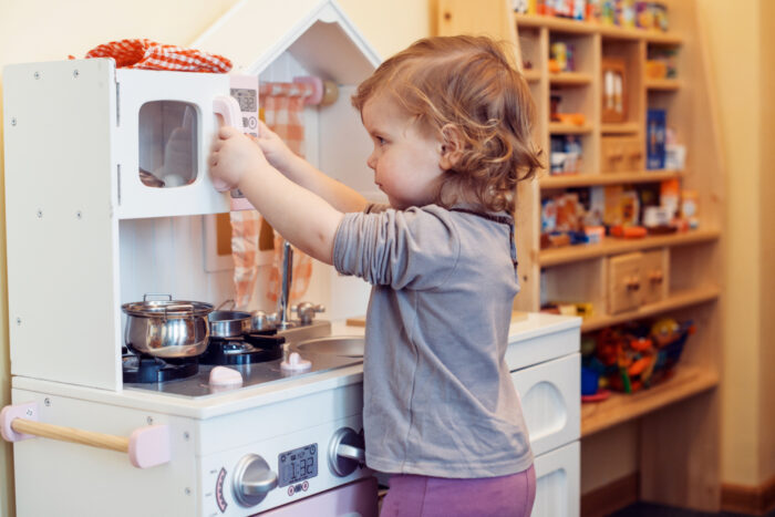 Little Girl Playing in her Play Kitchen