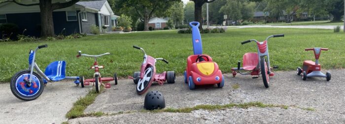 our collection of ride-on toys in the driveway