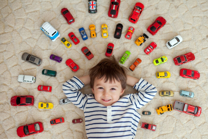 Little boy lying on floor with cars