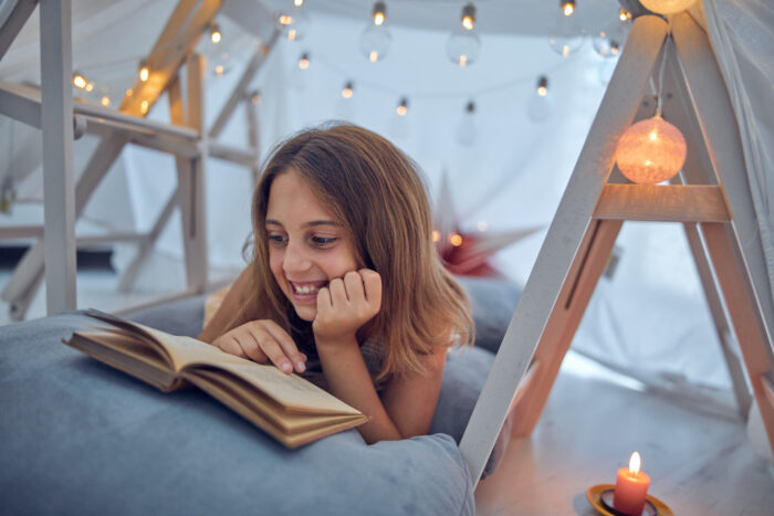 10 Year Old Girl Reading In Fort Tent