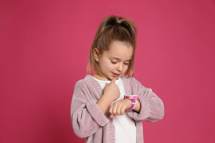 Little Girl Wearing Watch with Pink Background