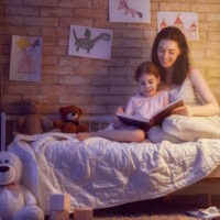 Mom and daughter reading together before bedtime